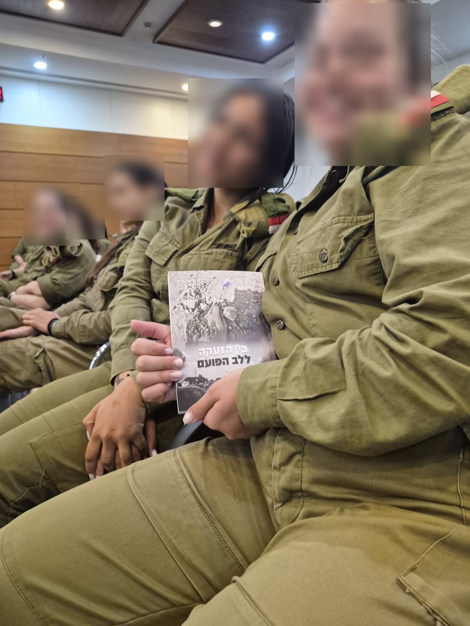חיילות מחזיקות את הספר ״בין הזעקה ללב הפועם״ בהרצאה